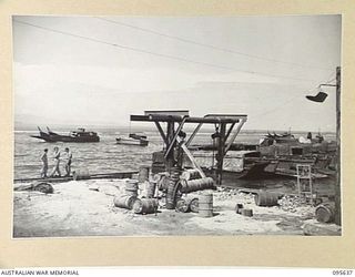 JACQUINOT BAY, NEW BRITAIN, 1945-08-31. THE VIEW, LOOKING EAST, OF AUSTRALIAN BARGES OF 53 PORT CRAFT COMPANY ROYAL AUSTRALIAN ENGINEERS, LINED UP ALONG THE BEACH