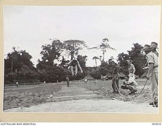 TOROKINA, BOUGAINVILLE, 1945-07-15. A COMPETITOR TAKING PART IN THE BROAD JUMP DURING THE COMBINED ALLIED SPORTS CHAMPIONSHIP MEETING AT GLOUCESTER OVAL ARRANGED BY AUSTRALIAN ARMY AMENITIES ..