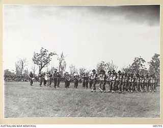 WONDECLA, ATHERTON TABLELAND, QLD. 1945-01-19. 2/48 INFANTRY BATTALION PLATOON TROOPS MARCH PAST TO THE MUSIC OF THE 2/48 INF BN BAND WHILE PARTICIPATING IN THE 9 DIVISION GYMKHANA AND RACE MEETING ..