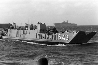 The utility landing craft LCU-1643 approaches the beach at Vieques, Puerto Rico, during Fleet Ex 1-90. In the background is the amphibious assault ship USS SAIPAN (LHA-2)