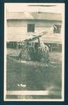 Two dukduks during dress rehersal, building in background with people watching from two windows, Rabaul, New Guinea, c1929 to 1931