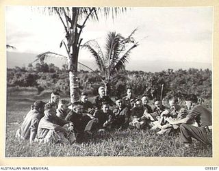 JACQUINOT BAY, NEW BRITAIN, 1945-08-25. SERGEANT A.M. MEMERE, INSTRUCTOR NO. 2 MOBILE TEAM LAND HEADQUARTERS SCHOOL OF ARMY EDUCATION LEADS A DISCUSSION ON POST WAR ECONOMIC PROBLEMS UNDER THE ..