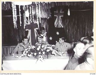 LAE, NEW GUINEA. 1944-05-20. P203 CAPTAIN F. J. POMEROY, OFFICER IN CHARGE, SUPPLY AND STORES SECTION, HEADQUARTERS NORTHERN REGION, AUSTRALIAN NEW GUINEA ADMINISTRATIVE UNIT (2), SEATED AMONG ..