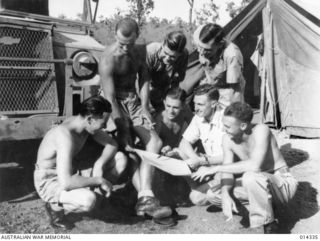 NEW GUINEA, 1943-02-25. CREWS OF A BEAUFIGHTER SQUADRON DISCUSS A STRAFING RAID OVER MADANG. LEFT TO RIGHT, STANDING, WING COMMMANDER B.R. WALKER (ADELAIDE, SA), SERGEANT F.B. ANDERSON (BANKSTOWN, ..