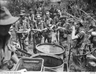 BOUGAINVILLE. 1945-04-17. MEMBERS OF D COMPANY, 58/59 INFANTRY BATTALION STOP FOR A DRINK OF WATER FROM 44 GALLON DRUMS ON A JEEP TRAILER BEFORE SETTING OUT ON PATROL DURING 24 INFANTRY BATTALION'S ..