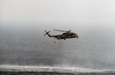 A right side view of a Helicopter Mine Countermeasures Squadron 14 (HM-14) RH-53D Sea Stallion helicopter towing a lightweight magnetic sweep during mine contermeasures operations. The helicopter is assigned to the amphibious assault ship USS GUAM (LPH 9). Note: Second view in a series of six