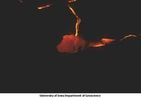 Lava showing through cracks and breaking out from under crust at night