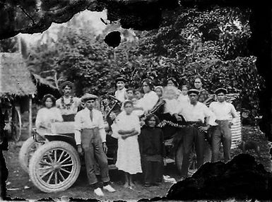 Group posing with a motorcar