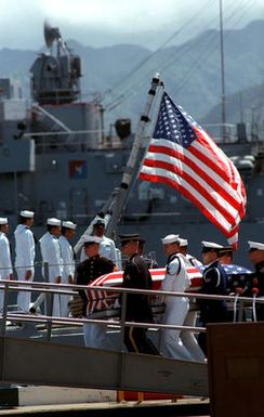 A joint services casket team carries the flag-draped casket of the Unknown Serviceman of the Vietnam Era toward the frigate USS BREWTON (FF 1086), at the conclusion of a wreath-laying ceremony. The casket will be transported to California and then transferred to Arlington National Cemetery for interment at the Tomb of the Unknowns