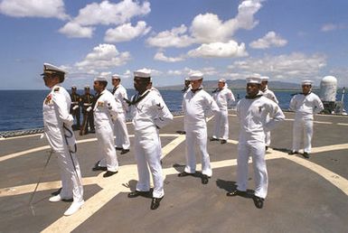 Crew members stand at parade rest aboard the USS BREWTON (FF 1086) at the conclusion of the designation and departure ceremony for the Unknown Serviceman of the Vietnam Era. The frigate is transporting the Unknown to to Naval Air Station Alameda, California