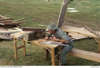 Corporal Steve Thomas taking levels for some piers at the local school. A replacement classroom was built out of the remnants of a destroyed building. This image relates to the service of Michael ..