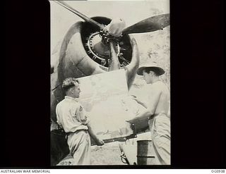 NADZAB, NEW GUINEA. C. 1944-02. LEADING AIRCRAFTMAN B. PIERCE, BONDI, NSW, ADMIRES A PAINTING OF RUBY LACEY, "ADOPTED" TIVOLI GIRL PERFORMER, BY CORPORAL E. STRACHAN, STRATHFIELD, NSW (RIGHT)