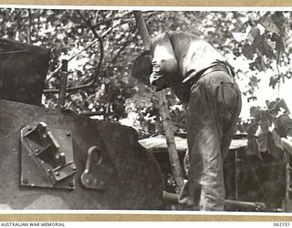 SCARLET BEACH AREA, NEW GUINEA. 1943-12-21. VX57267 CORPORAL H. A. NOLAN OF THE 1ST AUSTRALIAN TANK BATTALION GROUP WORKSHOP, AUSTRALIAN ELECTRICAL AND MECHANICAL ENGINEERS, ARC-WELDING A CRACK IN ..