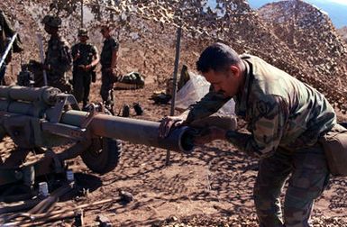 Corporal Rene Garcia, assistant gunner with the 4th Section of Battery C, 2nd Battalion, 11th Field Artillery, 25th Infantry Division, wipes the muzzle of an M-102 155 mm howitzer, during live-fire artillery exercise at the US Army's Pohakuloa Training Area