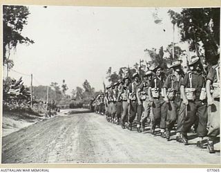 BOUGAINVILLE, 1944-11-21. PERSONNEL OF THE 9TH INFANTRY BATTALION PASSING THE SALUTING BASE DURING A REVIEW OF MEMBERS OF THE 7TH AUSTRALIAN INFANTRY BRIGADE BY THE COMMANDING GENERAL OF THE XIV ..