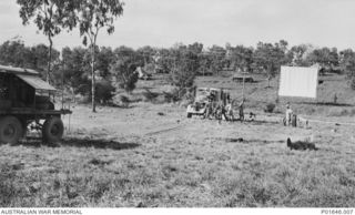 PORT MORESBY, PAPUA, 1942-1943. MOBILE CINEMA NO. 76, AUSTRALIAN ARMY AMENITIES SERVICE, SETTING UP TO SCREEN A FILM AT JOHN'S GULLY OUTSIDE PORT MORESBY. NOTE THE LARGE SCREEN AT THIS VENUE, 100 ..