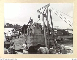 PURUATA ISLAND, SOUTH BOUGAINVILLE. 1945-05-29. A LE TOURNEAU CRANE BEING USED BY 42 LANDING CRAFT COMPANY TO PUT A BARGE INTO THE WATER. IT RAISES THE STERN CLEAR OF THE BEACH AND RUNS IT INTO THE ..