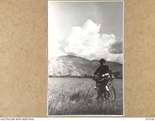 RAMU VALLEY, NEW GUINEA, 1943-10-01. SX4265 PRIVATE G.E. WOOD OF THE 2/27TH AUSTRALIAN INFANTRY BATTALION, RIDING A BICYCLE ON HIS PATROL ALONG THE VALLEY FLOOR