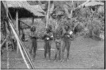 Fainjur: smoking men hold rolls of paper, other man and a boy