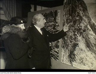 London, England. C. 1944-11-15. A photographic exhibition called "Australia at War" was shown at Simpson's Piccadilly, from 1944-11-07 to 1944-11-23. The Honourable S. M. Bruce and Mrs Bruce study ..