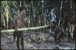 Pig festival: woman drinks bespelled water from bamboo tube held by elder