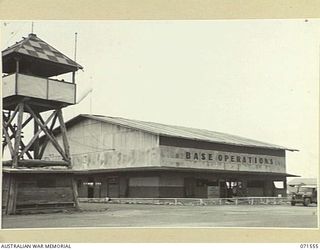 LAE, NEW GUINEA. 1944-03-23. HEADQUARTERS BASE OPERATIONS AT LAE AIRSTRIP, WITHIN THE HEADQUARTERS, LAE BASE SUB-AREA IS IN A RE-BUILT HANGAR WHICH WAS BADLY DAMAGED BY THE ROYAL AUSTRALIAN AIR ..