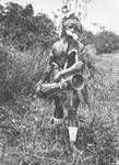 Man in ceremonial dress holding a drum, New Guinea, c1924 to ?