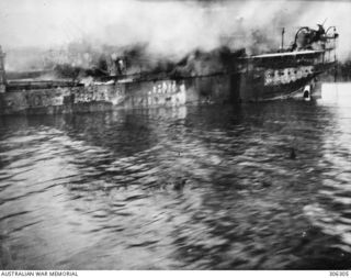 ORO BAY, NEW GUINEA. 1943-03-28. THE DUTCH SS BANTAM, ON FIRE AFT AND BEGINNNING TO SETTLE BY THE BOWS AFTER BEING BOMBED IN A JAPANESE AIR RAID IN THE COURSE OF OPERATION LILLIPUT. NOTE THE 12 ..