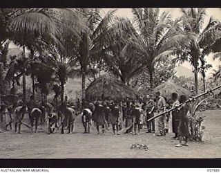 KAIAPIT, NEW GUINEA. 1943-09-24. NATIVES CLEARING UP THEIR VILLAGE FOR RE-OCCUPATION AFTER THE JAPANESE WERE DRIVEN OUT OF THE AREA