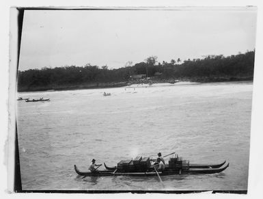 Canoe with boxes on board, and other canoes and boats in the distance, Mauke Island, Cook Islands