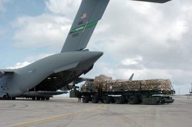 US Navy (USN) Seabees assigned to Naval Mobile Construction Battalion 7 (NMCB-7) load equipment and supplies onto a US Air Force (USAF) C-17 Globemaster III cargo aircraft on the island of Guam (GU), in support of Operation UNIFIED ASSISTANCE