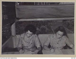 LAE, NEW GUINEA. 1945-05-15. PRIVATE M.A. O'BRIEN (1), AND PRIVATE M. CAMERON (2), AT HEADQUARTERS FIRST ARMY WORKING ON PROVISIONING OF RATIONS FOR THE AREA. A FEW DAYS AFTER THEIR ARRIVAL FROM ..
