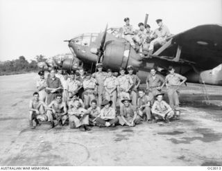 TADJI, NORTH EAST NEW GUINEA. 1945-06-27. GROUP PORTRAIT OF AIRCREW AND GROUND STAFF OF NO. 7 (BEAUFORT) SQUADRON RAAF. SOME ARE SITTING ON THE WING AND BESIDE A LINE OF AIRCRAFT ON THE AIRFIELD