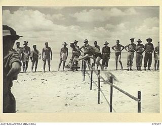 KELANOA, NEW GUINEA, 1944-02-20. CLEARING THE LAST JUMP DURING THE FIRST HEAT OF THE HURDLES AT A BEACH CARNIVAL ORGANISED BY THE AUSTRALIAN ARMY AMENITIES SERVICE, 5TH DIVISION