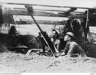 Salvaging this point five inch machine gun from an American plane, Sergeant Rowe (left) and Corporal Heartwell, improvised a support for it and used the gun as a light anti-aircraft weapon at Wau