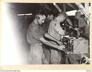 CAPE WOM, WEWAK AREA, NEW GUINEA, 1945-08-14. PERSONNEL OF THE TECHNICAL MAINTENANCE SECTION, SIGNALS, 6 DIVISION AT WORK ON COMMUNICATIONS EQUIPMENT