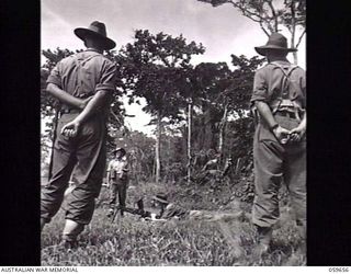 SOGERI, NEW GUINEA. 1943-11-04. SX23936 SERGEANT J. A. CURLIS (1), AN INSTRUCTOR OF THE NEW GUINEA FORCE TRAINING SCHOOL, LECTURING JUNIOR LEADERS ON THE OPERATION OF A BREN GUN. PUPIL IN THE PRONE ..