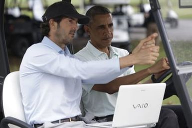 Barack Obama confers with Robert Baker after he plays golf in Kaneohe Bay, Hawaii, December 24, 2014
