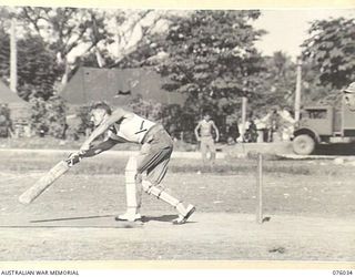 MADANG, NEW GUINEA. 1944-09-17. NX164637 PRIVATE G.A. SMITH (1) OPENING BATSMAN FOR THE 165TH GENERAL TRANSPORT COMPANY PLAYS A SHOT DURING THE CRICKET MATCH BETWEEN HIS TEAM AND A TEAM FROM THE ..