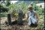 Anne Scheffler sitting beside a grave carving