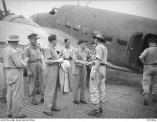 MILNE BAY, NEW GUINEA. 1944-04-21. THE HONOURABLE E.J. WARD, MINISTER FOR EXTERNAL TERRITORIES IN THE AUSTRALIAN GOVERNMENT (3), WITH MEMBERS OF THE OFFICIAL PARTY, BIDDING FAREWELLS ALONGSIDE A ..