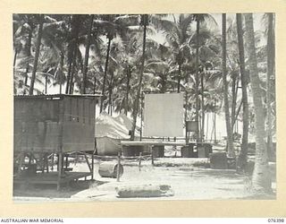 LABU, NEW GUINEA. 1944-10-03. "COCONUT GROVE" THE THEATRE OF THE 1ST WATERCRAFT WORKSHOPS WITH THE YOUNG MEN'S CHRISTIAN ASSOCATION AT THE LEFT OF THE SCREEN