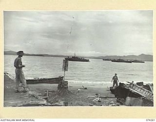HANSA BAY, NEW GUINEA. 1944-06-22. VX109228 CORPORAL KRAEMER, 5TH DIVISION PROVOST CORPS, (LEFT) SURVEYING THE FAST ROYAL AUSTRALIAN NAVY ML'S (MOTOR LAUNCHES) ANCHORED IN THE BAY