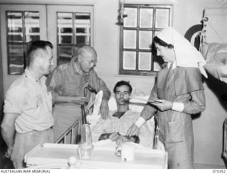 NX70851 Major S S Roseberry, Medical Officer (second from left) and NFX119136 Sister D B McMahon (right) examining Corporal F J Block (in bed) a patient aboard the 2/1st Hospital Ship Manunda