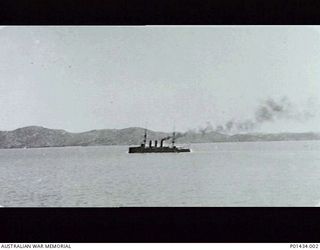 PORT MORESBY, NEW GUINEA. 1914-08. THE LIGHT CRUISER HMAS ENCOUNTER, SMOKE ISSUING FROM HER REAR FUNNEL, ABOUT TO LEAVE THE HARBOUR TO CARRY OUT PATROL DUTY. (ORIGINAL PRINT HELD IN AWM PR91/102)