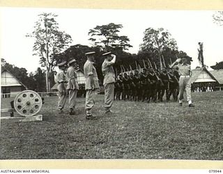 LAE, NEW GUINEA. 1945-03-27. LORD WAKEHURST, KCMG, GOVERNOR OF NEW SOUTH WALES (4), TAKES THE SALUTE DURING THE MARCH PAST OF THE ROYAL PAPUAN CONSTABULARY AT THEIR UNIT