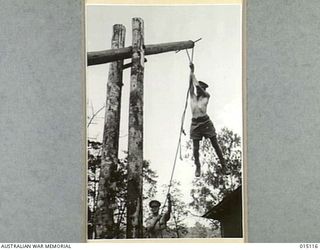 1943-06-26. NEW GUINEA. AT A CONVALESCENT CAMP SOMEWHERE IN NEW GUINEA. PHYSIOTHERAPY TREATMENT IS GIVEN TO RESTORE INJURED MUSCLES AND NERVES. DRIVER N. POTTER OF KEMPSEY, N.S.W. HANGING TO THE ..