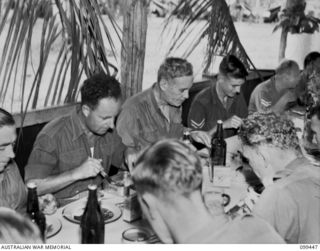 LAE, NEW GUINEA, 1945-12-25. THE RIGHT HONOURABLE J. B. CHIFLEY, PRIME MINISTER OF AUSTRALIA (2) HAVING CHRISTMAS DINNER AT NO 1 OTHER RANKS' MESS, FIRST AUSTRALIAN ARMY, DURING HIS VISIT TO THE ..
