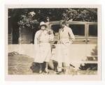 Woman, holding a koala, and man standing in front of a motor vehicle, c1900 to ?