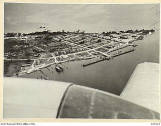 MANUS ISLAND, ADMIRALTY ISLANDS. 1949-09. VIEW OF LOMBRUM, NAVAL HEADQUARTERS ON MANUS ISLAND. SHOWING WHAT WILL BE THE MAIN WORKSHOP AND WHARFAGE AREA